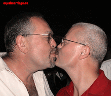 Ian Taylor (Never Say "No Comment" Inc.) and spouse George Olds, celebrate with a kiss (Photo by equalmarriage.ca, 2002)